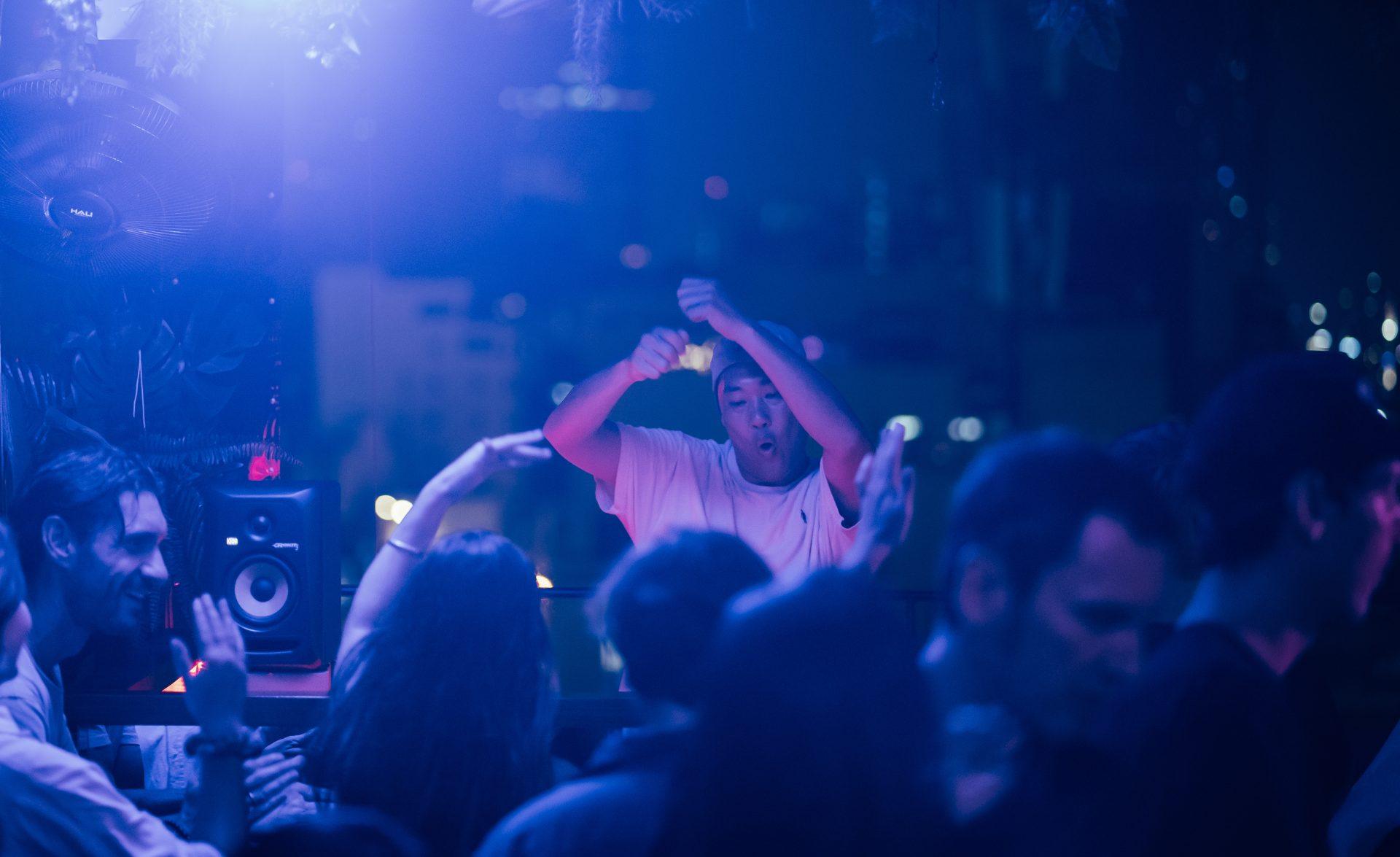 DJ Nhan Solo performing at Momento Rooftop with guests dancing during an event
